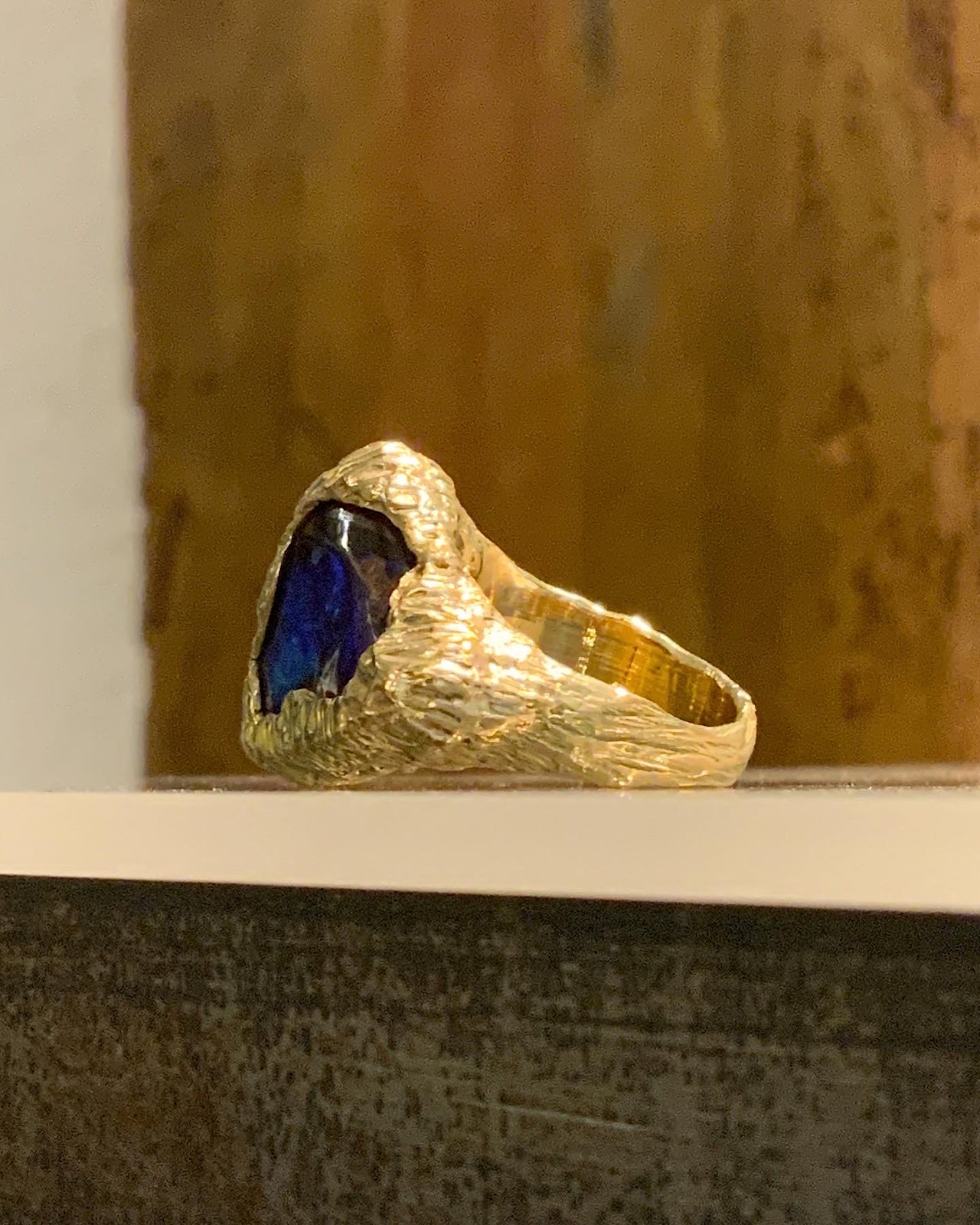 Anillo de plata con piedra azul y banda de oro
