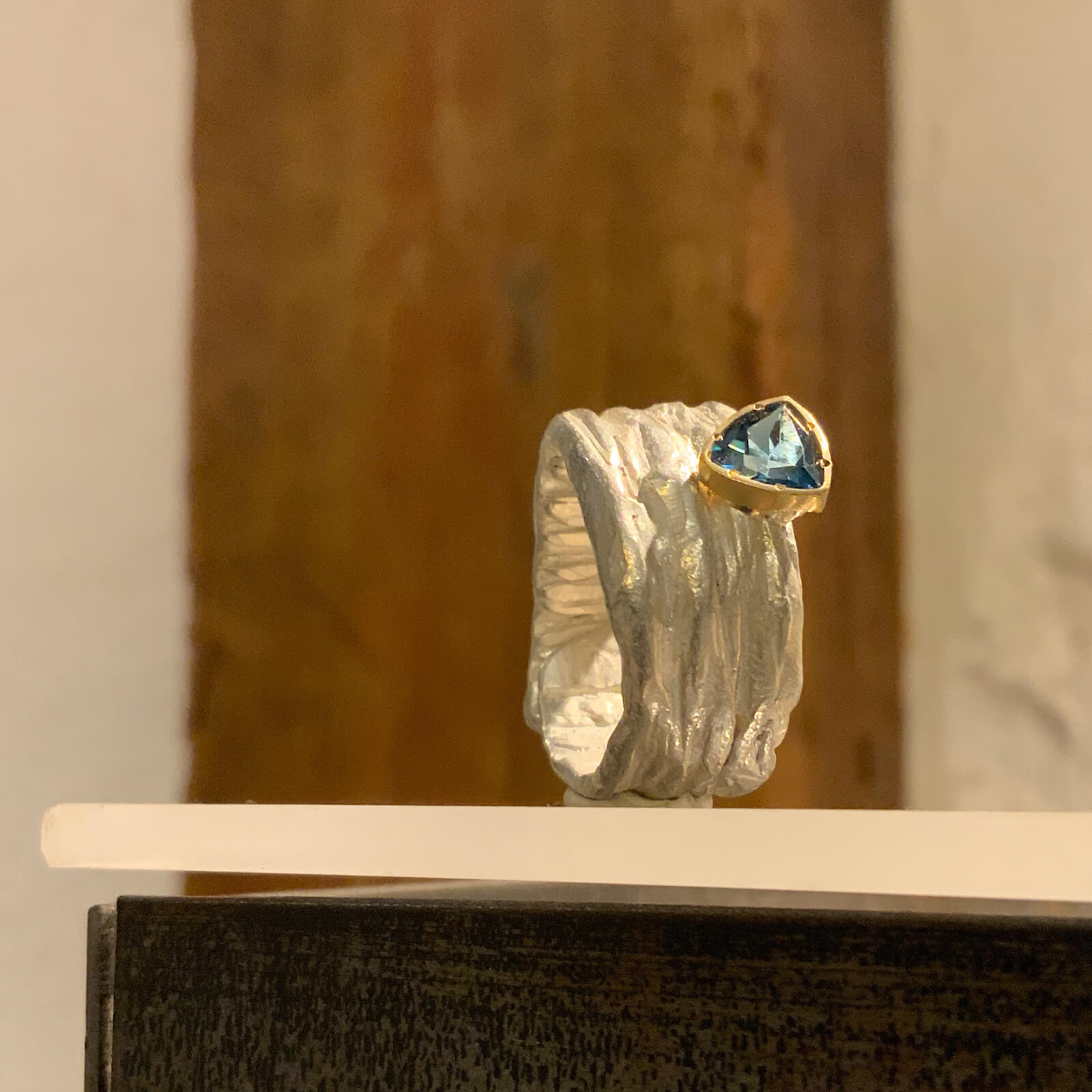 Anillo de plata esculpida con topacio azul