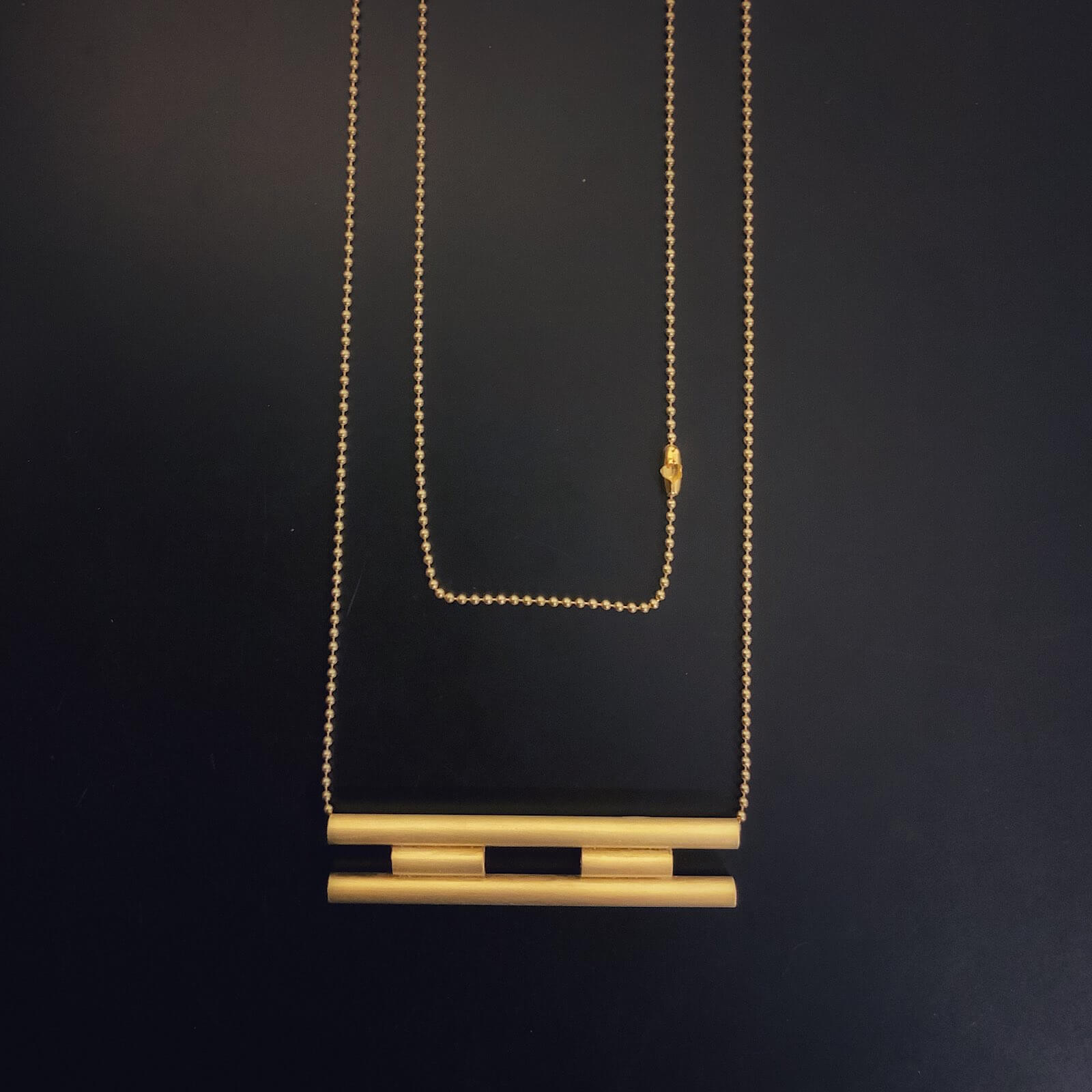 Colgante de barras de oro superpuestas